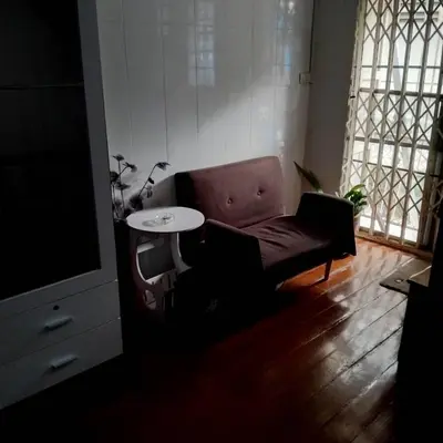 a living room with a couch and a table at Sleepwith me Hostel in Bangkok
