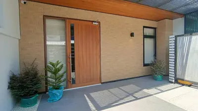a front door of a house with two potted plants at Smile Residence at Kaset-Sena in Ban Yang