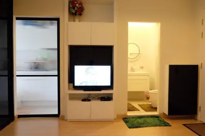 a living room with a television in a white cabinet at HIGH RISE LUXURY CONDO 1BED ROOF TOP POOL 2 MinMRT in Bangkok