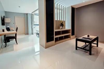 a living room with a desk and a table at Three Sukhumvit Hotel - SHA Plus Certified in Bangkok
