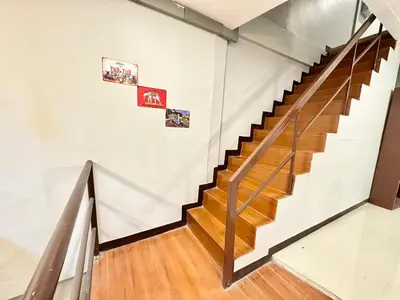 a staircase in a building with pictures on the wall at Baan at Khaosan Hostel in Bangkok