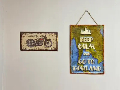 a sign hanging on a wall with a motorcycle on it at Baan at Khaosan Hostel in Bangkok