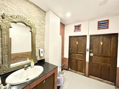 a bathroom with a sink and a mirror and two doors at Baan at Khaosan Hostel in Bangkok