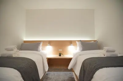 a room with two beds and a desk between them at E11 Hotel - BTS Punnawithi in Amphoe Phra Khanong