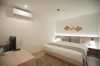 a bedroom with a bed and a desk with a television at E11 Hotel - BTS Punnawithi in Amphoe Phra Khanong