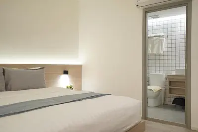 a bedroom with a white bed and a bathroom at E11 Hotel - BTS Punnawithi in Amphoe Phra Khanong