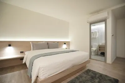 a white bedroom with a large bed and a window at E11 Hotel - BTS Punnawithi in Amphoe Phra Khanong