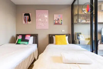 two beds sitting next to each other in a room at BTS S5 Surasak 900 meters near the Mekong River Pier Free Swimming Pool in Ferris Wheel Night Market Chinese Reception Bangkok Center in Lat Krabang
