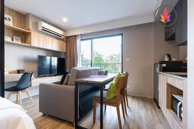 a kitchen and a living room with a table and a couch at BTS S5 Surasak 900 meters near the Mekong River Pier Free Swimming Pool in Ferris Wheel Night Market Chinese Reception Bangkok Center in Lat Krabang