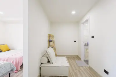a white bedroom with a bed and a chair at Advanced townhouses can accommodate 14 people, with high-speed Wi Fi and parking on Netflix in Ban Non Yang Ngam