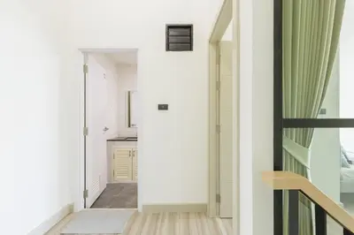 a hallway of a house with white walls and a staircase at Advanced townhouses can accommodate 14 people, with high-speed Wi Fi and parking on Netflix in Ban Non Yang Ngam