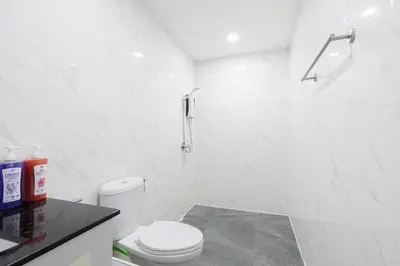 a white bathroom with a toilet and a shower at Advanced townhouses can accommodate 14 people, with high-speed Wi Fi and parking on Netflix in Ban Non Yang Ngam