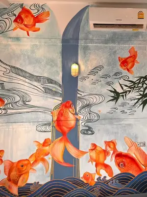 a painting of gold fish on a wall at Suraya Bangkok in Bangkok