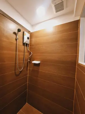 a bathroom with a shower with wooden walls at Suraya Bangkok in Bangkok