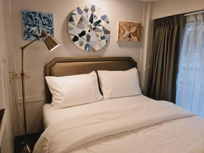 a bedroom with a bed and a lamp and mirrors at Suraya Bangkok in Bangkok