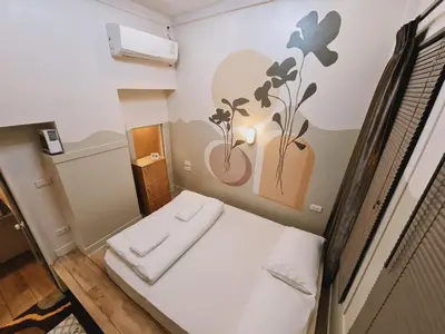 a small room with a bed with two towels on it at Suraya Bangkok in Bangkok