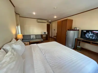 a bedroom with a white bed and a television at Jhouse Thonglor in Khlong Toei