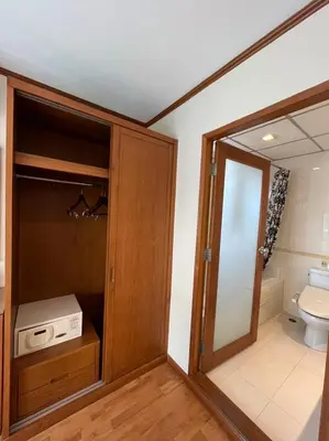 a bathroom with a toilet and a cabinet with a window at Jhouse Thonglor in Khlong Toei