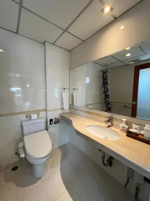 a bathroom with a toilet and a sink and a mirror at Jhouse Thonglor in Khlong Toei