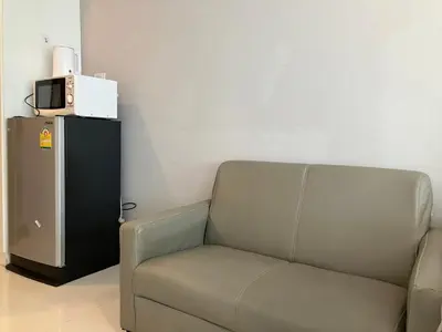 a living room with a couch and a microwave at 2 mins walk to BTS Bang Chak in Bangkok