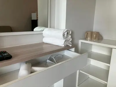 a bathroom with a shelf with towels and a mirror at 2 mins walk to BTS Bang Chak in Bangkok