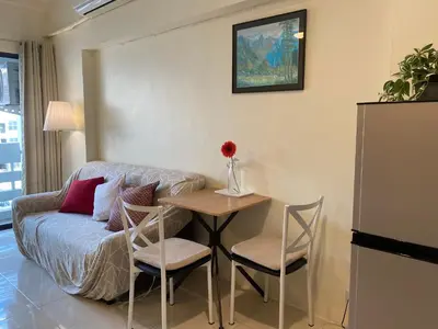 a living room with a table and a couch at Cozy 1br walk to BTS and Airport Rail Link Close to Malls m11 in Bangkok