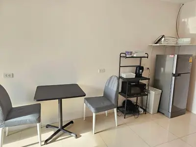a room with two chairs and a table and a refrigerator at Cozy 1br walk to BTS and Airport Rail Link Close to Malls m11 in Bangkok