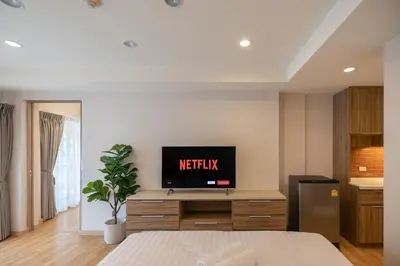 a bedroom with a television on a wooden dresser at Exoresidence The Heart of Chinatown in Bangkok
