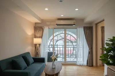 a living room with a blue couch and a large window at Exoresidence The Heart of Chinatown in Bangkok