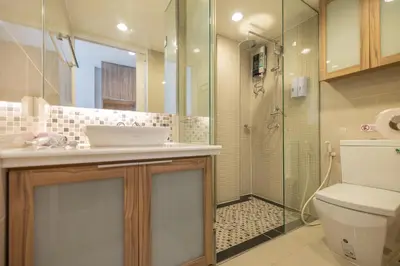 a bathroom with a toilet and a glass shower at Exoresidence The Heart of Chinatown in Bangkok