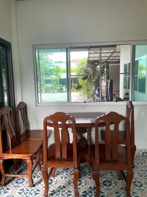 a dining room table with four chairs and a window at K house in Ban Bang Khen (1)