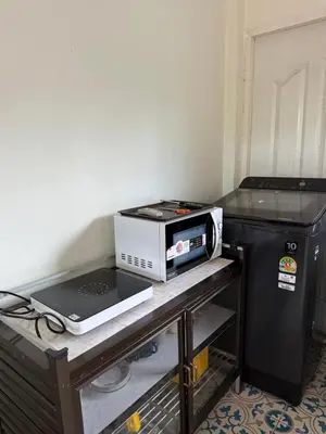 a microwave sitting on a table next to a refrigerator at K house in Ban Bang Khen (1)