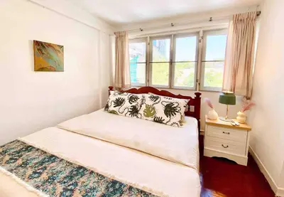 a small bedroom with a bed and a window at Flip Flop In Townhouse in Bangkok