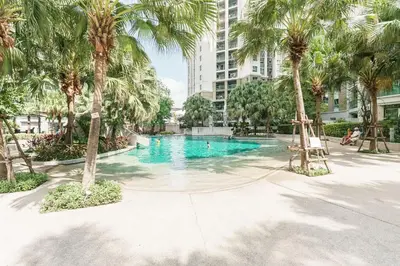 a swimming pool with palm trees and a building at Internet celebrity train night market swimming pool free WiFi mrt 100m in Ban Tha Satu