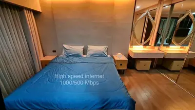 a bedroom with a blue bed and a large mirror at 1BR Thonglor , Fast WiFi , Near Samitivej , Nightlife in Khlong Toei