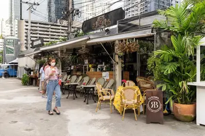 a woman is standing in front of a restaurant at MRT rame9 Jodd Fairs night market, walk for a few minutes, two bedrooms and two bathrooms in Ban Don Sai