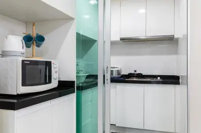 a kitchen with white cabinets and a microwave at MRT rame9 Jodd Fairs night market, walk for a few minutes, two bedrooms and two bathrooms in Ban Don Sai