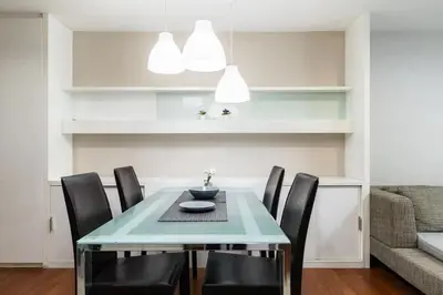 a dining room with a table and black chairs at MRT rame9 Jodd Fairs night market, walk for a few minutes, two bedrooms and two bathrooms in Ban Don Sai