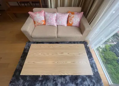 a living room with a couch with pink and orange pillows at 2 Bedroom Luxury Apartment 3 min walk from BTS Ekkamai in Bangkok
