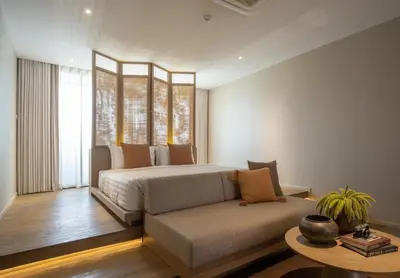 a bedroom with a bed and a couch and a table at Stay Plus Hotel Bangkok in Bangkok