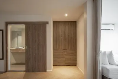 a bedroom with a door leading to a bathroom at Stay Plus Hotel Bangkok in Bangkok