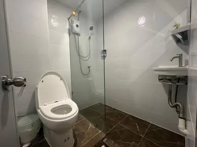 a bathroom with a toilet and a shower and a sink at The White Den Sukhumvit 44 in Bangkok