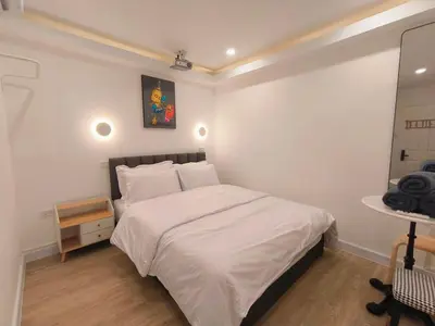 a bedroom with a white bed and a mirror at The White Den Sukhumvit 44 in Bangkok