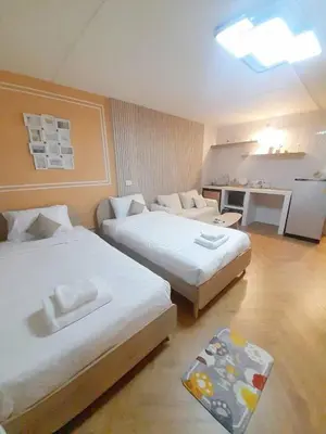 a hotel room with two beds and a desk at NK hostel in Thung Si Kan