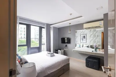a bedroom with a bed and a large window at Dazzle Sukhumvit 7 by LeFoyer in Bangkok