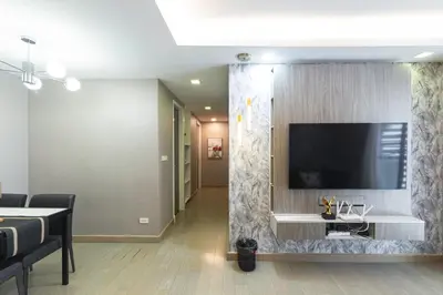 a living room with a flat screen tv on a wall at Dazzle Sukhumvit 7 by LeFoyer in Bangkok