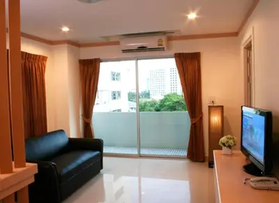 a living room with a couch and a large window at Love mansion in Bangkok