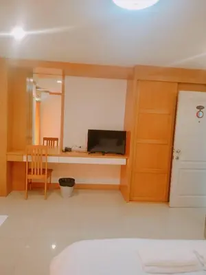 a living room with a television and a table with a chair at Love mansion in Bangkok