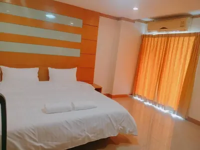 a bedroom with a large white bed and a window at Love mansion in Bangkok