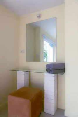 a bathroom with a counter with a mirror and a stool at Baan Khun Pra APT No4 Duplex 3BR in Bangkok